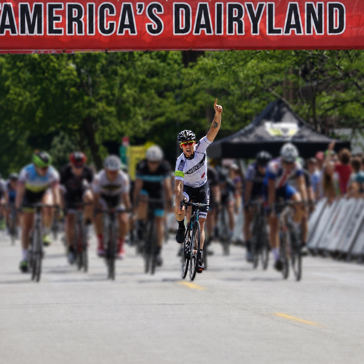 A cyclist celebrating a race win with a raised arm